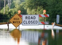 Flooded road with High Water and Road Closed signs